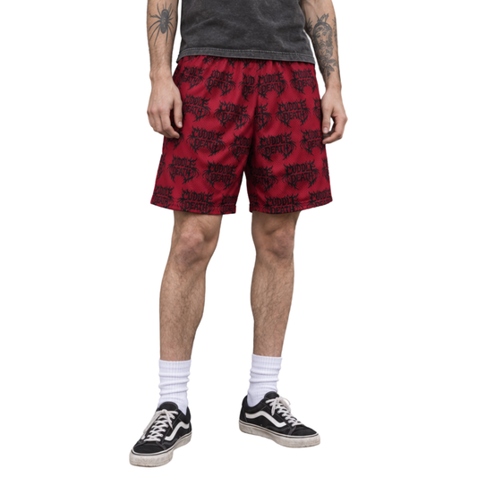 Model wearing red Cuddle Death mesh shorts with a charcoal T-shirt and black skate shoes.