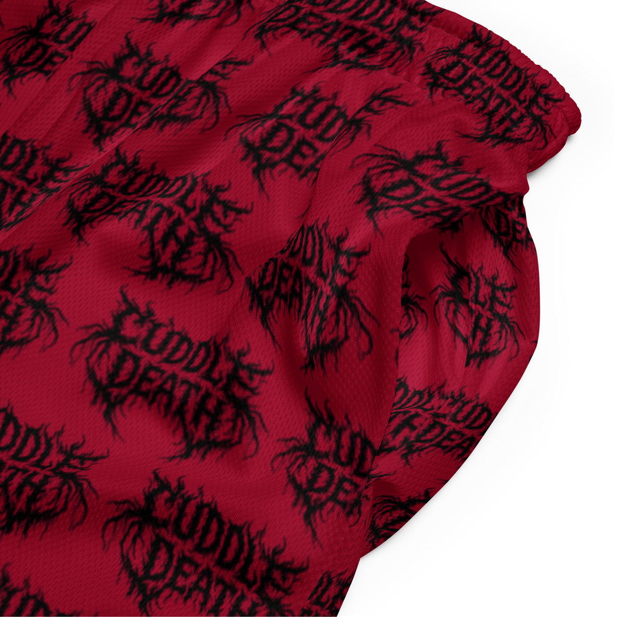 Product detail of red Cuddle Death mesh shorts with an all-over black logo print.